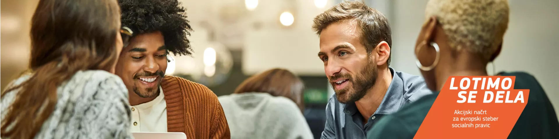 Raznolika skupina mladih, ki sedijo in se pogovarjajo.  