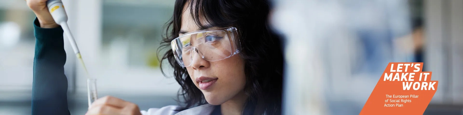 Young woman wearing protective glasses making measurements with a pipette and test tube in a laboratory setting